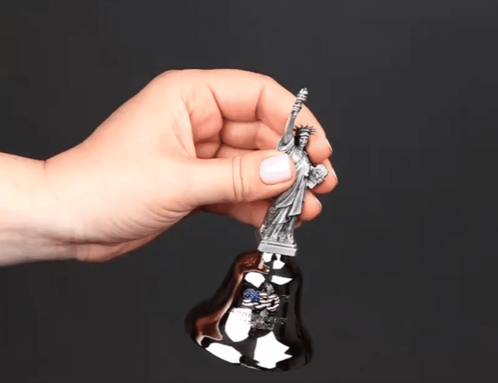 Hand holding Statue of Liberty souvenir bell
